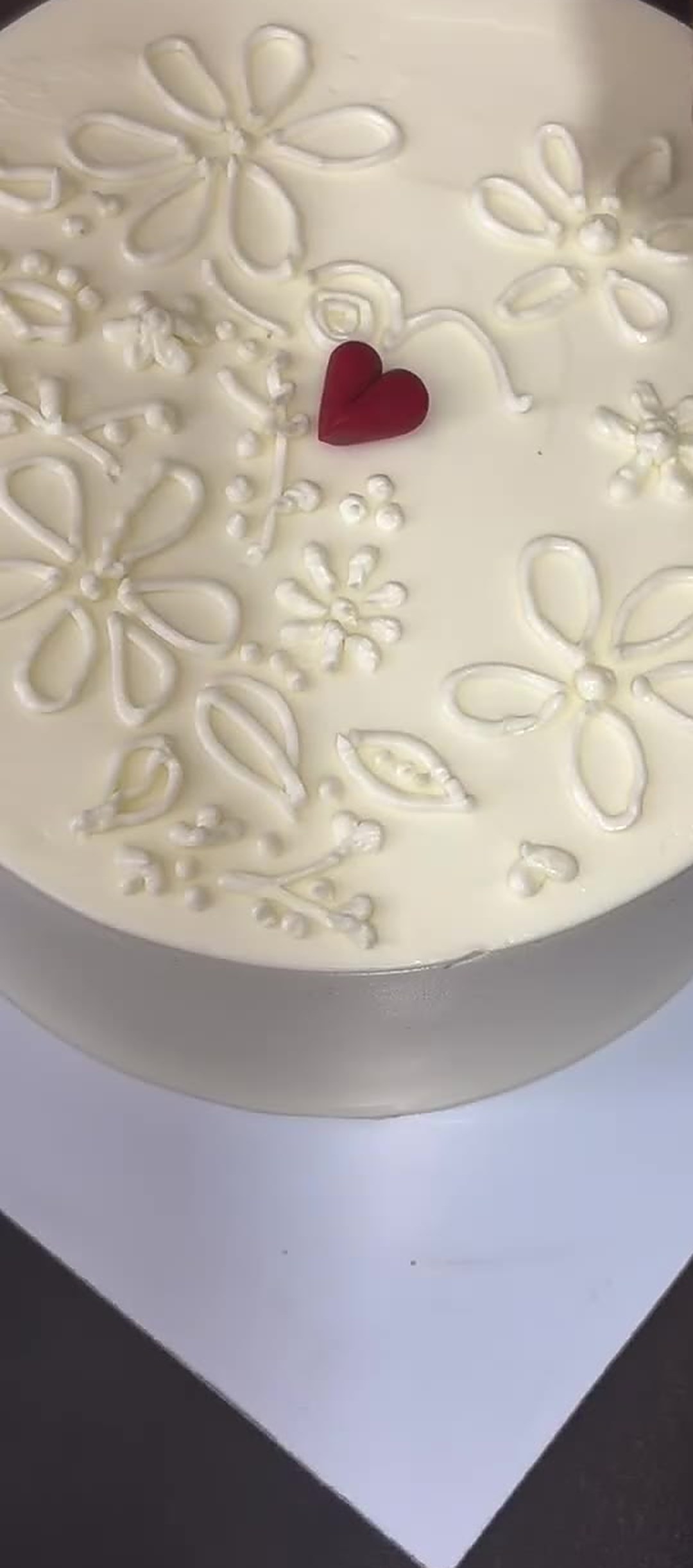 White bento cake with delicate piping and a single red heart